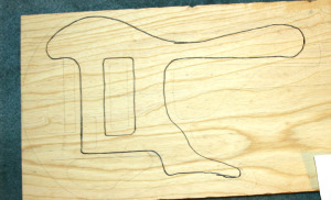 The swamp ash has been planed and the chambers are drawn onto the body blank