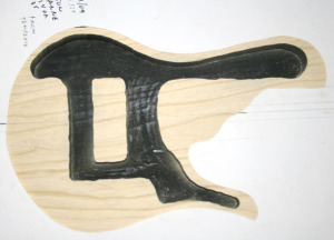 The swamp ash body core (bath tub) done with the body shape overlayed. The chamber is painted black to make the soundholes black in the final bass